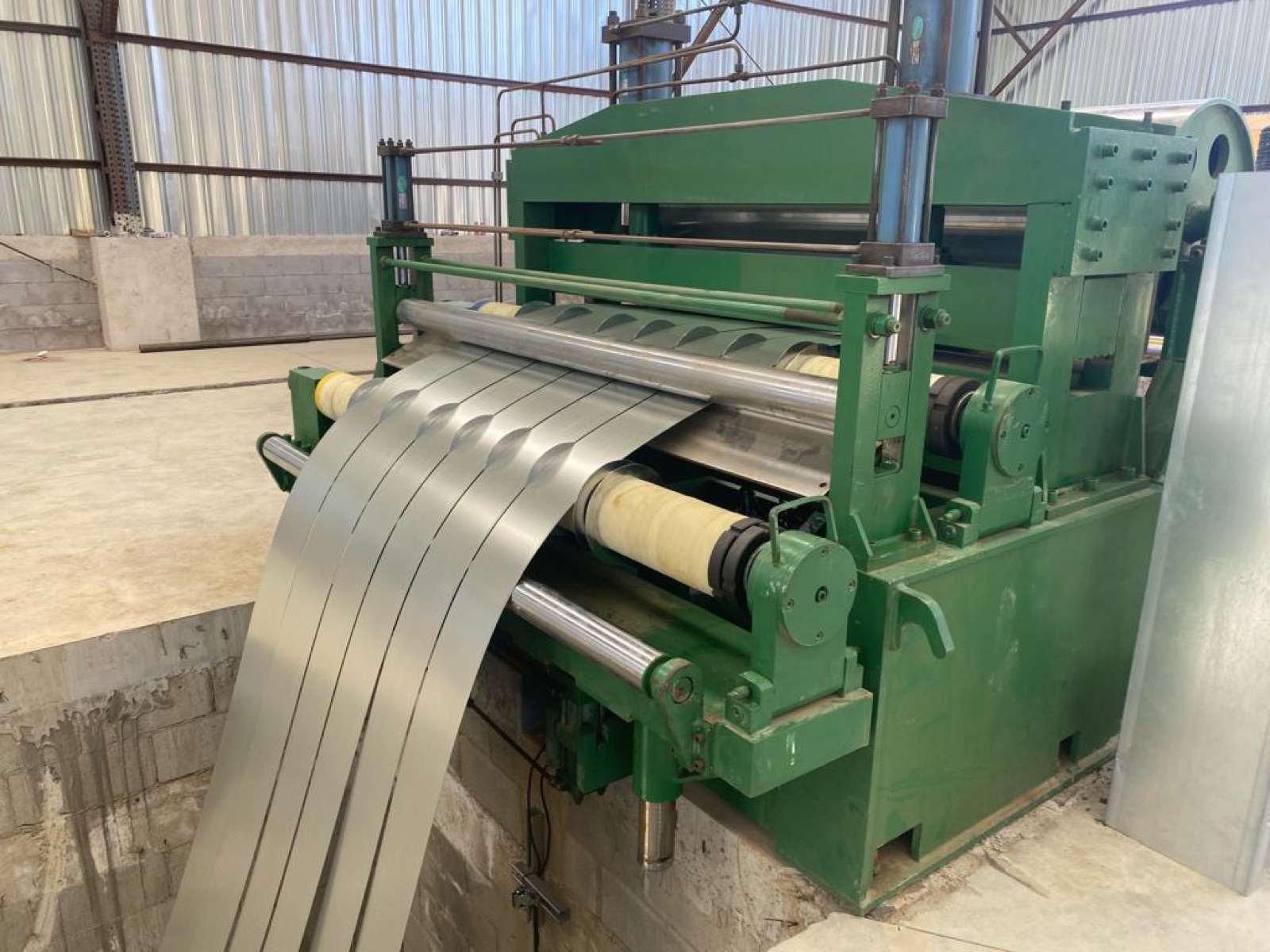 Slit steel feeding into a roll-forming machine.