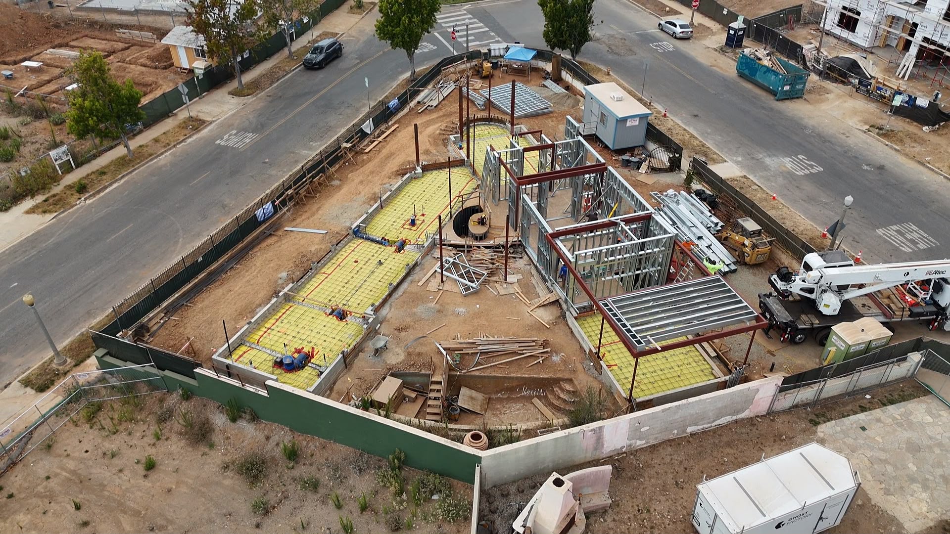 Aerial of the red-oxide structural steel frame and light gauge steel framing rising across the 777 Ocampo site