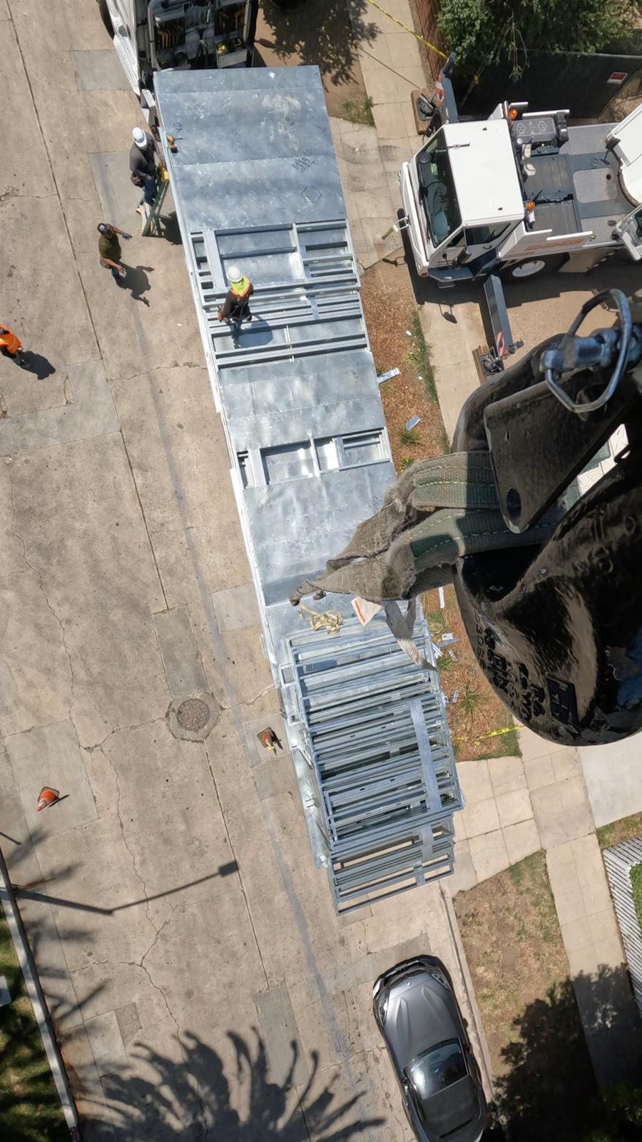 Aerial view from the crane hook of a wall panel staged with the crew below