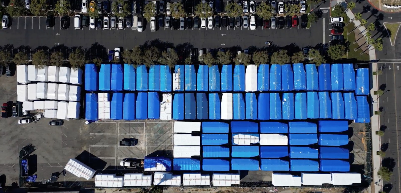Aerial view of wrapped volumetric modules staged in rows at the yard before delivery